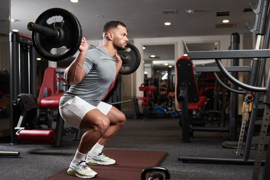 persona realizando sentadilla tradicional con barra en gimnasio